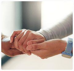 Two hands, one older and one younger, gently holding each other