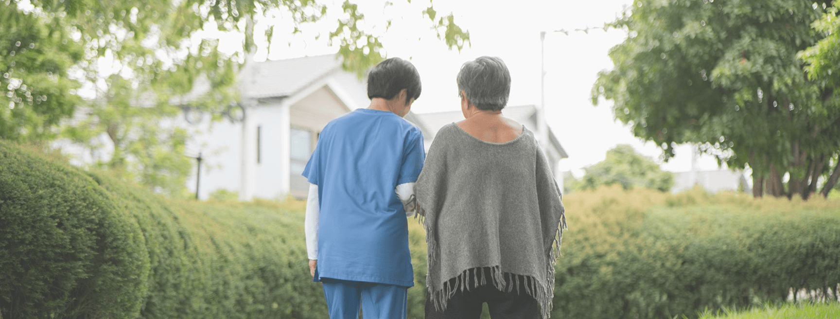Caregiver and elderly client smiling together in a warm indoor setting